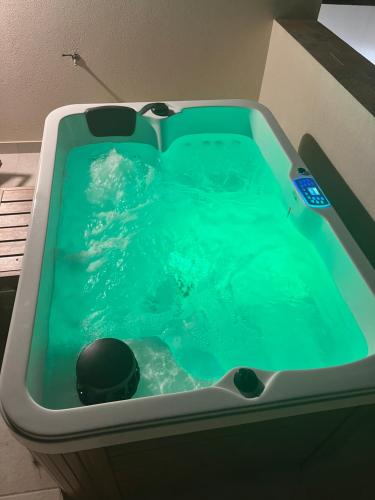 a bath tub filled with blue water in a room at MANZIL Country House in Valderice