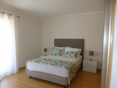 1 dormitorio con 1 cama grande y 2 almohadas en Algarve T2 apartment with pool and balcony in Olhão, en Olhão