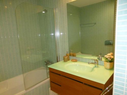 y baño con lavabo, ducha y espejo. en Algarve T2 apartment with pool and balcony in Olhão, en Olhão