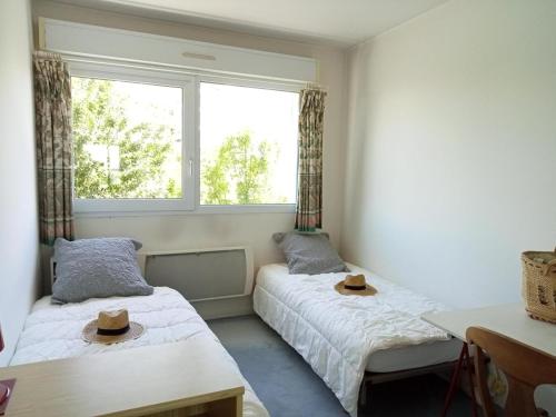 Deux lits dans une pièce avec deux chapeaux dans l'établissement Appartement Vue Mer à La Rochelle 6 Pers. - FR-1-551-57, à La Rochelle