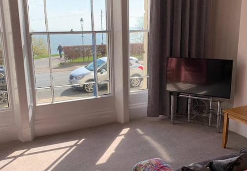 a living room with a view of a car outside a window at Crescent View - Panoramic sea views in Filey