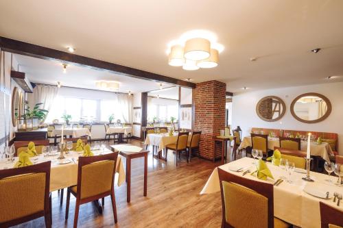 een restaurant met tafels en stoelen in een kamer bij Bernsteinsee Hotel in Sassenburg