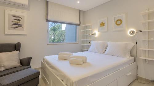 a bedroom with a white bed with two towels on it at Keiko in Almancil