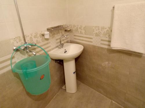La salle de bains est pourvue d'un lavabo et d'un seau. dans l'établissement Pearl Cottage Airport, à Karachi