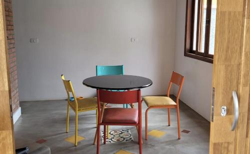 Una mesa y cuatro sillas en una habitación en CASA AZUL São Pedro en São Pedro