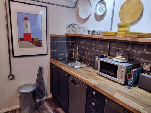 a kitchen with a counter with a microwave on it at The Old Bakery in Berwick-Upon-Tweed
