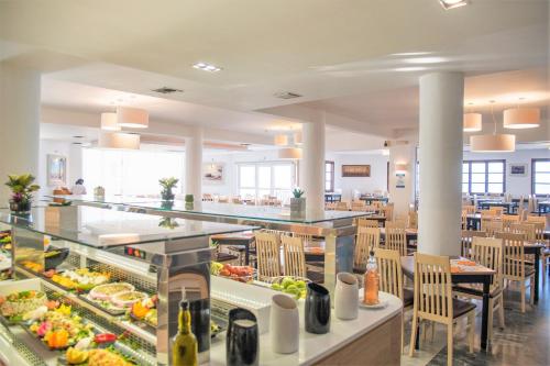 a cafeteria with a buffet line with food at Semiramis Village Hotel in Hersonissos