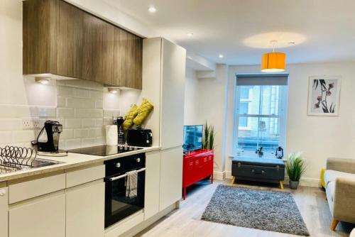 a kitchen with white counters and a red cabinet at Sofias Flat in Bournemouth