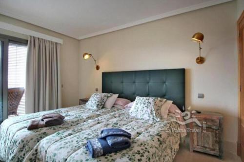 1 dormitorio con 1 cama grande y cabecero azul en Apartamento de dos dormitorios con Wifi y frente a playa en Puerto de Tazacorte en Tazacorte