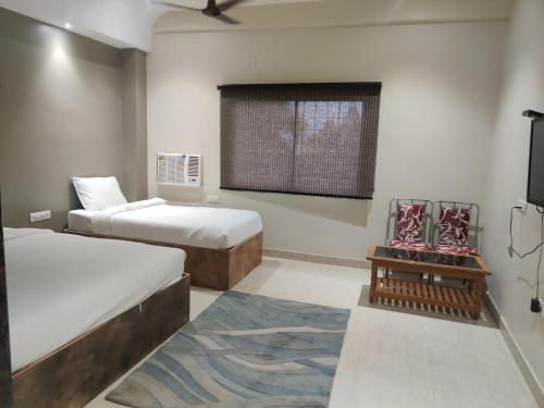 Habitación con 2 camas y TV. en Hotel Sukhdham, en Allahābād