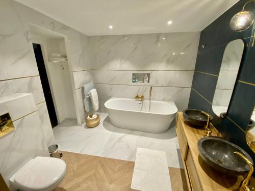 a bathroom with a tub and a toilet and a sink at Superbe appartement terrasse et parking gratuit in Auxerre