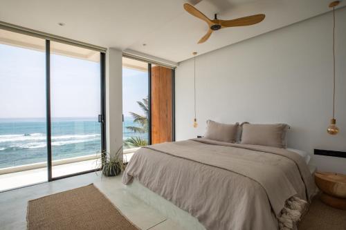 a bedroom with a bed and a ceiling fan at The Hotel in Ahangama