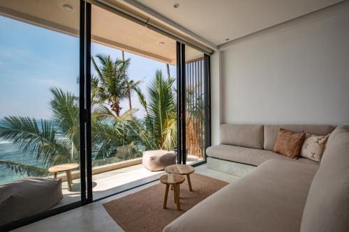 a living room with a couch and a large window at The Hotel in Ahangama