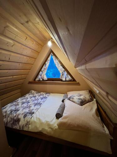 Domek Długa في زاكوباني: سرير صغير في غرفة مع نافذة