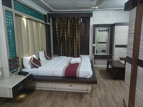 a bedroom with a bed and a desk and a window at Hotel Midtown in Haridwār