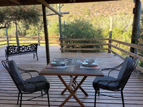a wooden table and chairs on a wooden deck at Assegai Rest in Robertson