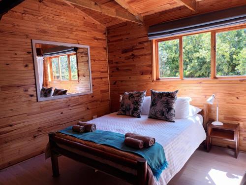 um quarto com uma cama num chalé de madeira em Assegai Rest em Robertson