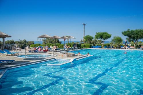 a swimming pool at a resort with people in it at Semiramis Village Hotel in Hersonissos