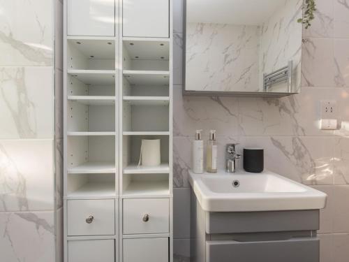 W białej łazience znajduje się umywalka i lustro. w obiekcie Pass the Keys Luxury 1 Bed Flat on Windsor Riverside w mieście Windsor
