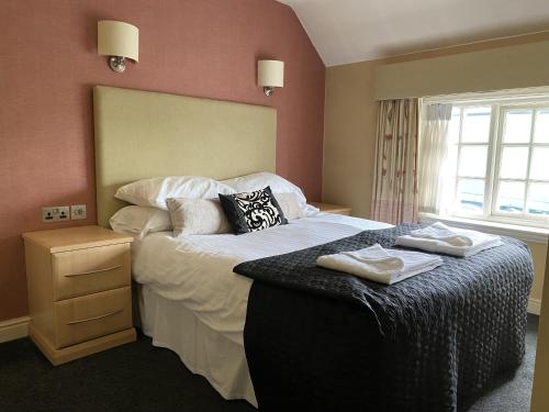 a bedroom with a large bed with two towels on it at The Windmill Inn 