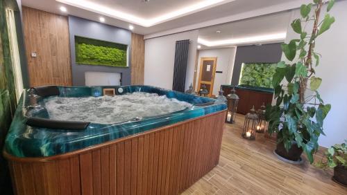 Siedem Drzew في Biskupice: حوض استحمام كبير في غرفة بها نباتات