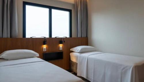 um quarto de hotel com duas camas e uma janela em SALINAS PREMIUM RESORT em Salinópolis