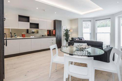a kitchen and a living room with a table and chairs at Roomspace Serviced Apartments - Lockwood House in Surbiton