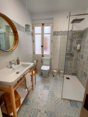 a bathroom with a sink and a toilet and a shower at Tirwal Suite in Teruel