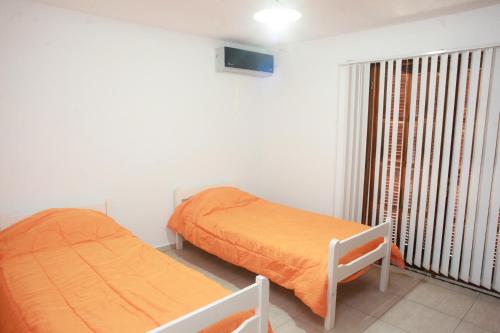 1 dormitorio con 2 camas y ventana en Complejo Alberdi - Alquiler temporario en San Rafael