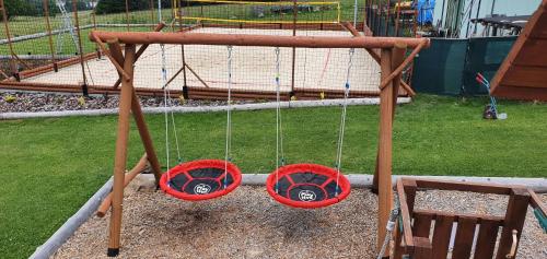 three swings in a park with a playground at Apartmány Srub Výtoňka Lipno in Přední Výtoň