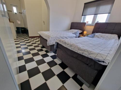 two beds in a room with a checkered floor at Apartmani Carla in Medulin