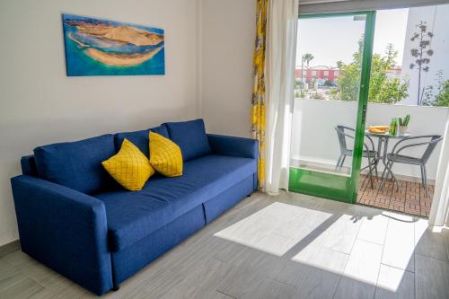 a blue couch with yellow pillows in a living room at New & Renovated Vacation Apartment in Costa de Antigua