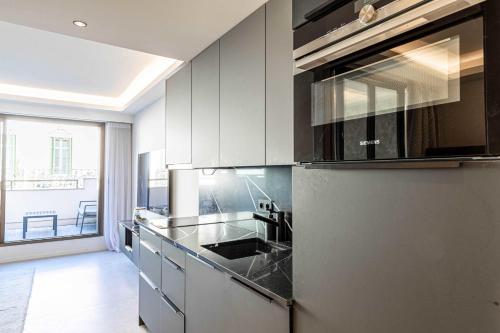 La cuisine est équipée d'un réfrigérateur et d'un évier. dans l'établissement Superb One bedroom flat and terrace - Cannes center, à Cannes
