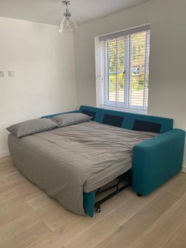 uma cama num quarto com uma cama azul em Spacious and Cosy 2 Bedroom Flat in Bermondsey em Londres