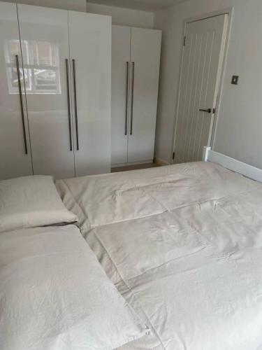 a large white bed in a room with a closet at Spacious and Cosy 2 Bedroom Flat in Bermondsey in London