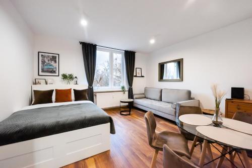 a bedroom with a bed and a couch and a table at Żoliborz Elite Apartment in Warsaw