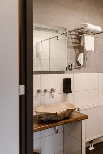 a bathroom with a stone bowl on a counter at Hotel Torpedoloods in Hoek van Holland