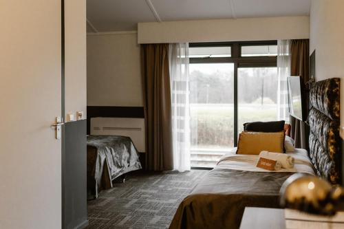 una camera d'albergo con letto e finestra di Hotel Torpedoloods a Hoek van Holland