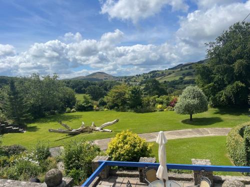 a view of a garden with a bench and a tree at Pentre Cerrig Country House in Llanferres
