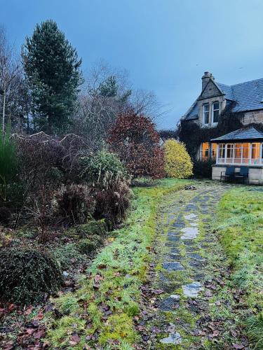 a house with a driveway in front of a yard at St Duthus Villa Guesthouse in Tain