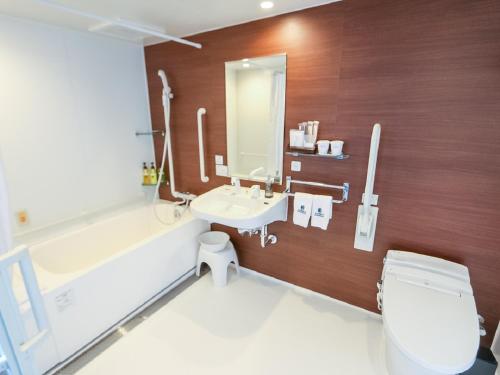 een badkamer met een toilet, een wastafel en een bad bij HOTEL LiVEMAX Takadanobaba Ekimae in Tokyo