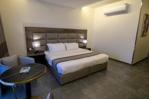a hotel room with a large bed and a table at Arayik Resort in Taif