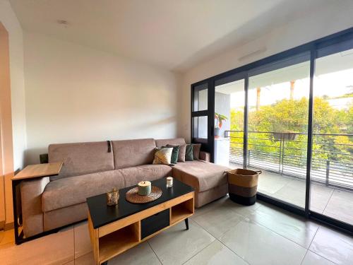 ein Wohnzimmer mit einem Sofa und einem Tisch in der Unterkunft STUDIO avec terrasse 400m Croisette / Rue d’Antibes in Cannes