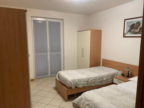 パヴィアにあるMood-San Matteo Residence Parva Urbiのベッドルーム1室(ベッド2台、クローゼット付)