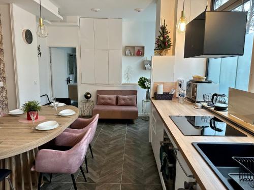 une cuisine et un salon avec une table et des chaises dans l'établissement Logement GUÉNOT pour 5 personnes sur Paris 11, à Paris