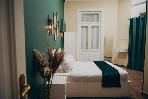 een slaapkamer met een bed en een groene muur bij Hathor House in Caïro