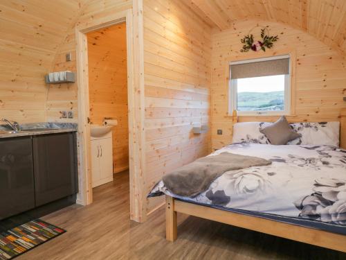 1 dormitorio con 1 cama en una cabaña de madera en Cherry en Ulverston