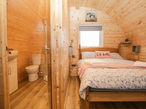 a bedroom with a bed in a wooden cabin at Willow in Ulverston