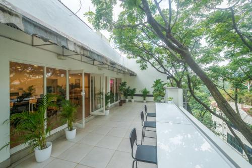an outdoor patio with a long table and chairs at Olive Magrath - By Embassy Group in Bangalore