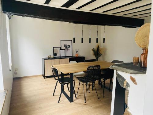 een eetkamer met een houten tafel en stoelen bij L'antre du loup in Stavelot